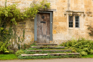 Old wooden door in a honey-coloured wall in Stanton