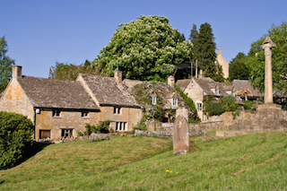 Cottages and war memorial in Bibury, with a horse chestnut tree in bloom