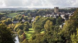 View across parkland to the town of richmond, with the massive castle towering over its surroundings